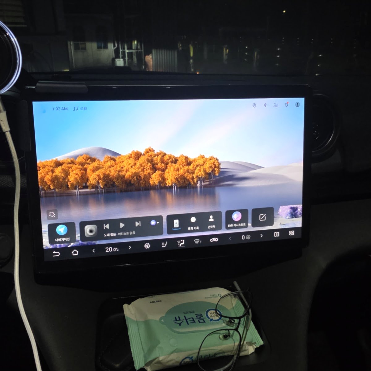 BYD 돌핀 가운데 화면과 왼쪽 끝에 고정한 둥근 휴대폰 거치대, 오른쪽의 동그란 송풍구