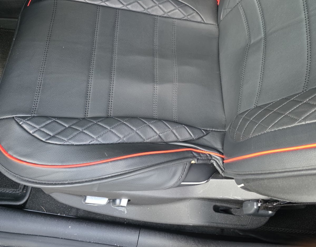 BYD 돌핀 운전석에 씌운 검은색 시트 커버, 가장자리에 빨간 줄과 다이아몬드 박음질